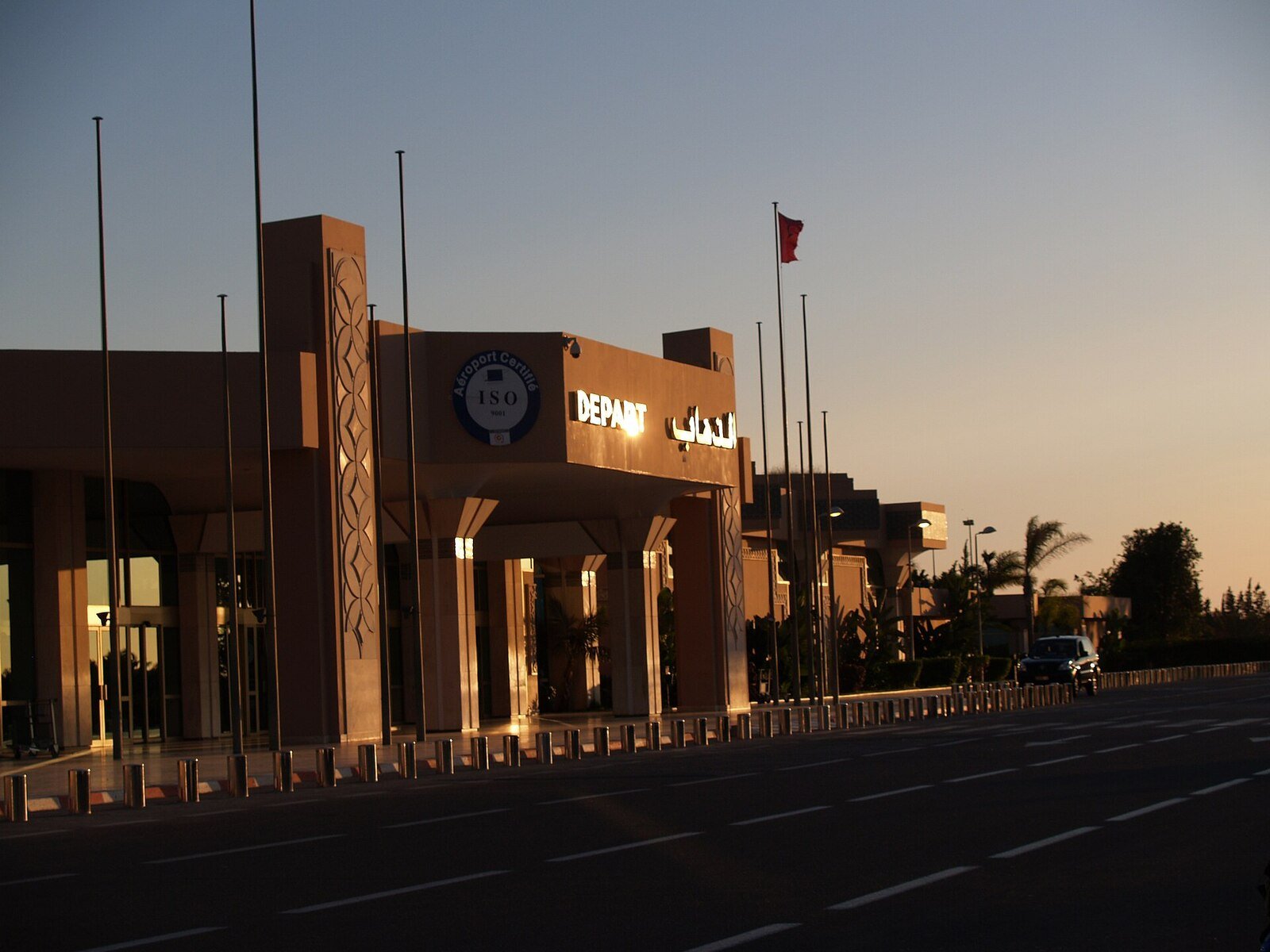 An airliner on the apron beside a jet bridge.